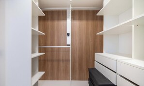 A walk-in closet with wooden paneling, white shelving, and a bench. - Penthouse With Ocean View Ingleses Mhc0306 (Florianópolis)
