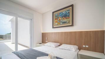 Un dormitorio moderno con una cama grande, un cuadro y un balcón.