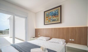 A modern bedroom with a large bed, a painting, and a balcony. - Penthouse With Ocean View Ingleses Mhc0306 (Florianópolis)
