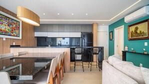 A modern kitchen with a central island, black chairs, and a dining table. - Penthouse With Ocean View Ingleses Mhc0306 (Florianópolis)