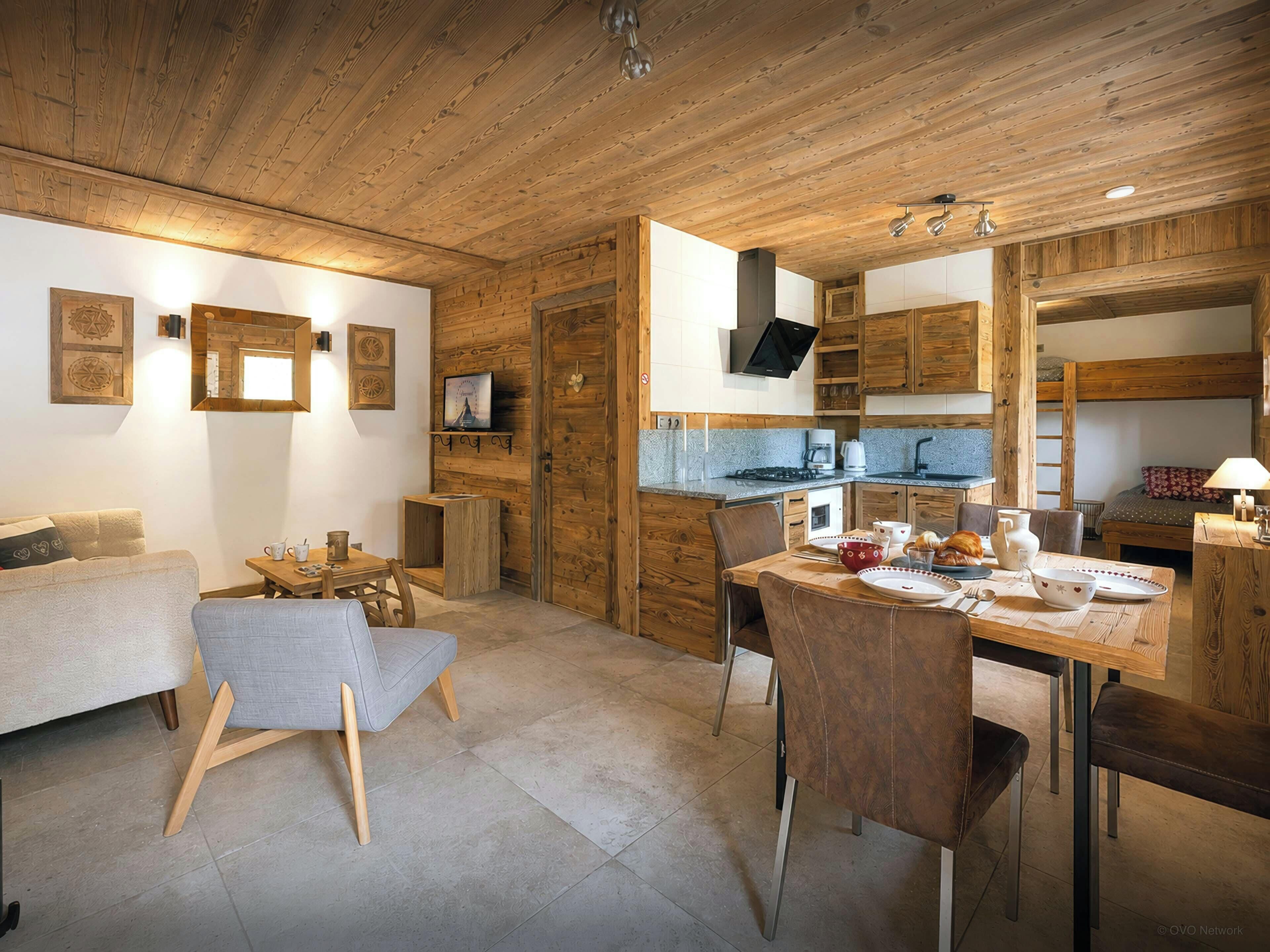 A cozy interior with a dining area, kitchen, and seating space.