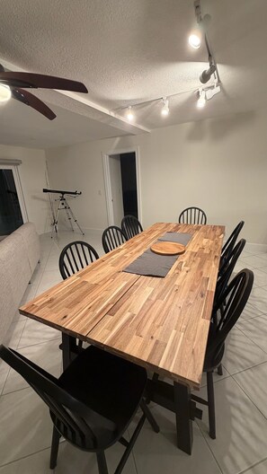 A dining area with a wooden table, black chairs, and a ceiling fan. - Beach House in Indian Rocks Beach | 4 bedrooms with pool (Indian Rocks Beach)