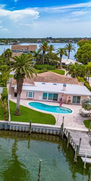 A residential property with a swimming pool, a dock, and a view of a body of water. - Beach House in Indian Rocks Beach | 4 bedrooms with pool (Indian Rocks Beach)