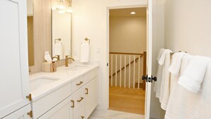 Un bagno con due lavandini, uno specchio e un porta asciugamani.