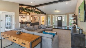 A spacious living area with a large sectional sofa, a wooden coffee table, and a dark console table. - Private Scottsdale Oasis - Pool, Spa & Casita (Scottsdale)