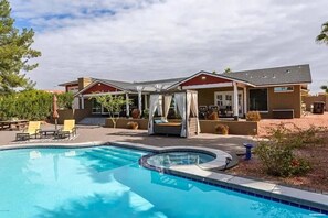 Propiedad residencial con piscina, zona de estar al aire libre y patio cubierto.