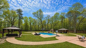 A backyard with a swimming pool, a slide, a gazebo, and a hammock. - Sleeps 16 | Pool + Slide | Family Retreat (Porter)