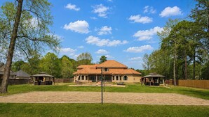 A residential property with a large house, a fenced yard, and a sandy play area. - Sleeps 16 | Pool + Slide | Family Retreat (Porter)