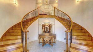 A grand staircase with a chandelier, leading to an upper level. - Sleeps 16 | Pool + Slide | Family Retreat (Porter)