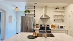Une cuisine moderne équipée d’un réfrigérateur en acier inoxydable, d’une cuisinière encastrée et d’un four à micro-ondes.
