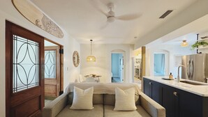Un intérieur moderne comprenant un canapé, un coin repas et une cuisine.