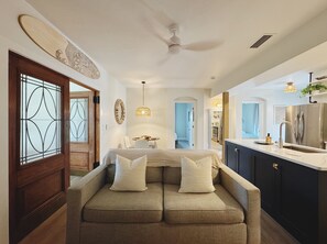 Ein modernes Interieur mit einer Couch, einem Essbereich und einer Küche.