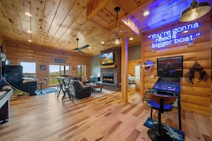 A cozy cabin interior with a fireplace, wooden floors, a pool table, and a neon sign. - Grandfather Mountain Views, Hot Tub, Game Room & Putting Green (Seven Devils)