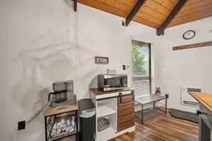 A compact kitchen with a coffee maker, microwave, and a small trash bin. - Cozy 2BR retreat near Beech Mountain Resort. (Beech Mountain)