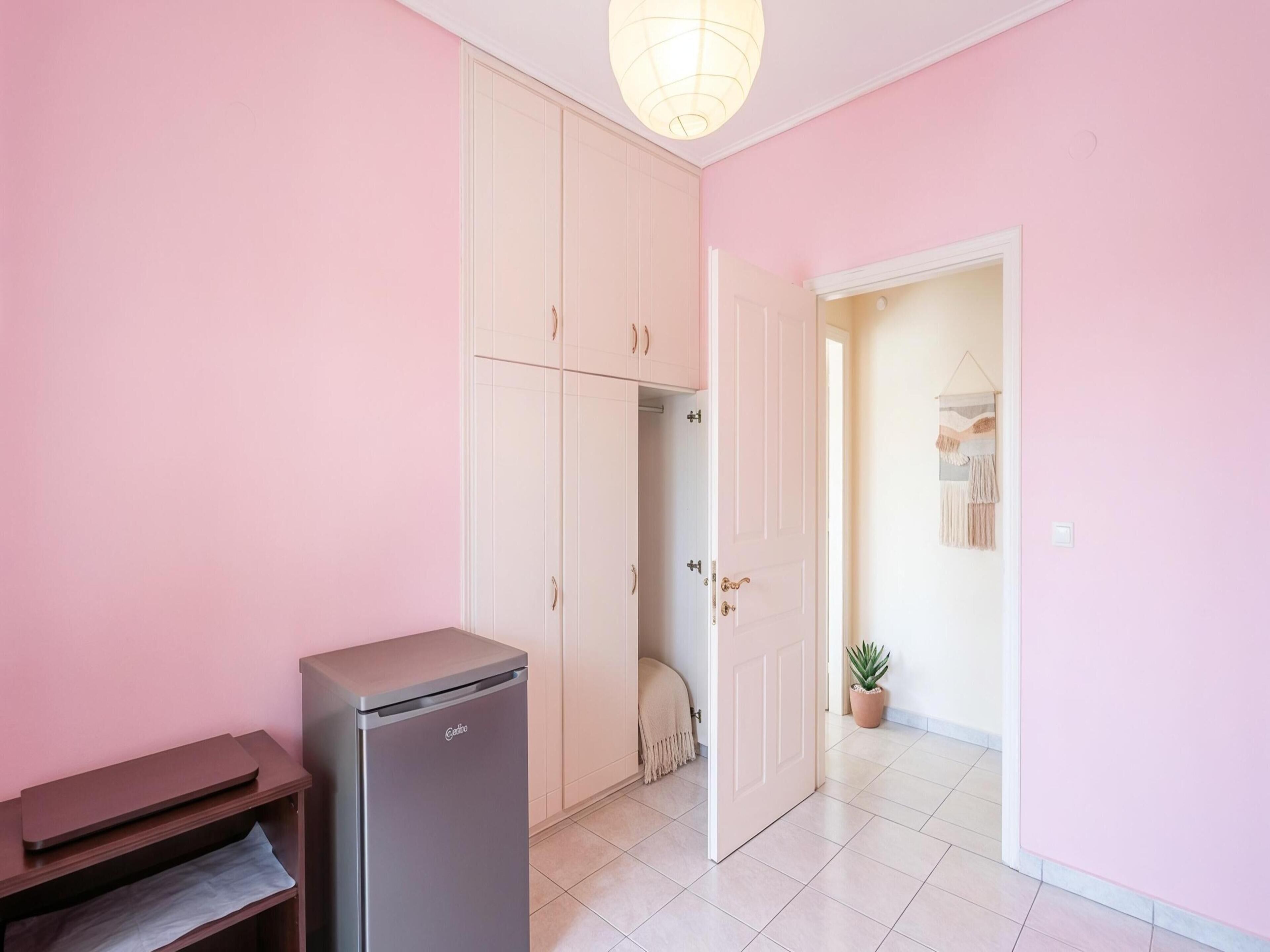 Une pièce dotée d’une kitchenette, d’une armoire et d’une porte donnant sur une autre pièce.