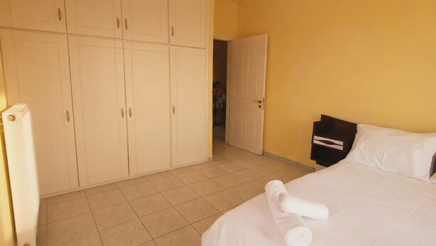 Una habitación de hotel con cama, un armario y una puerta que da a otra habitación.