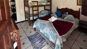 A bedroom with a bunk bed, a single bed, a ceiling fan, and a tiled floor.
