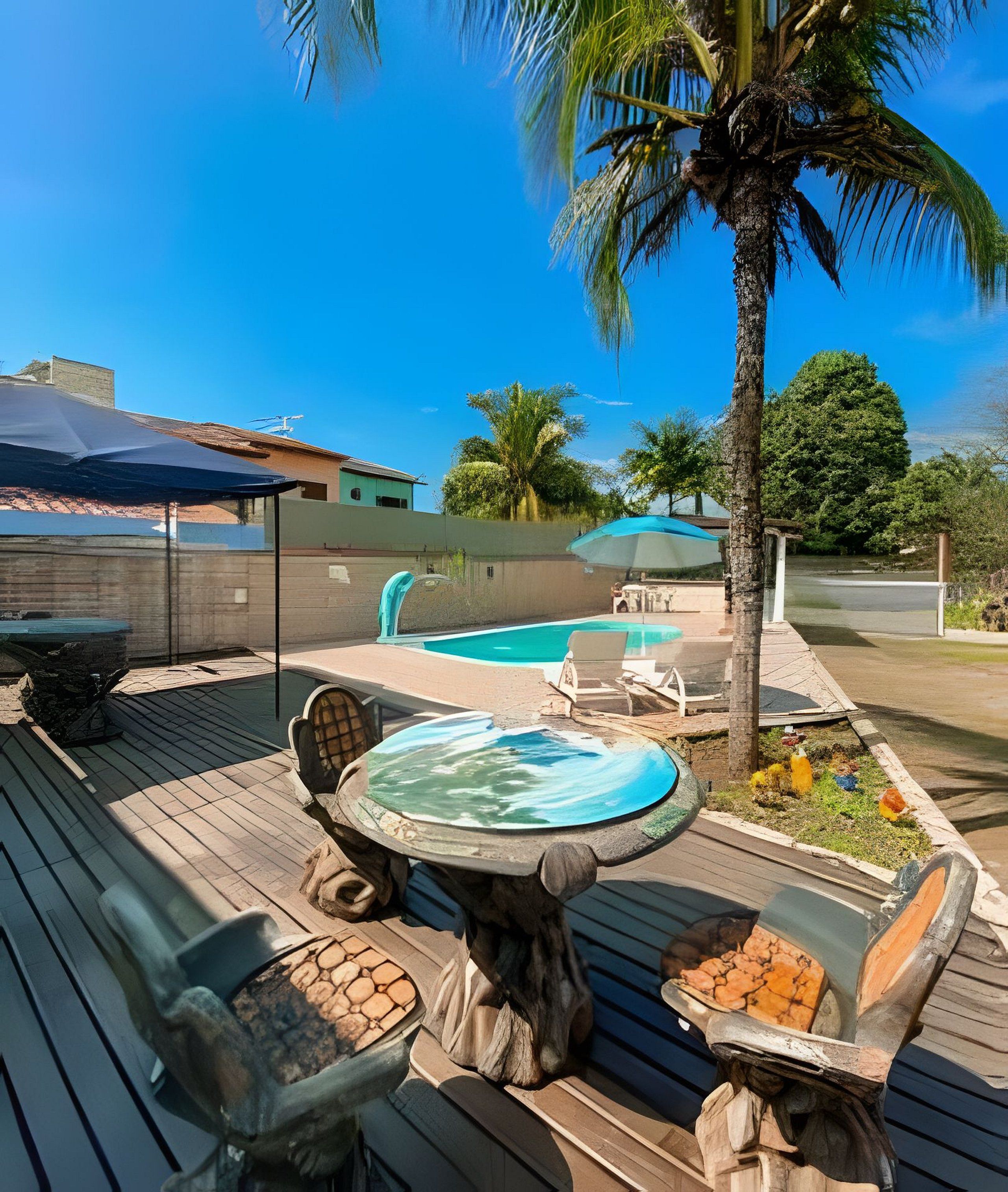 Um deck de madeira com hidromassagem, piscina e espreguiçadeiras.