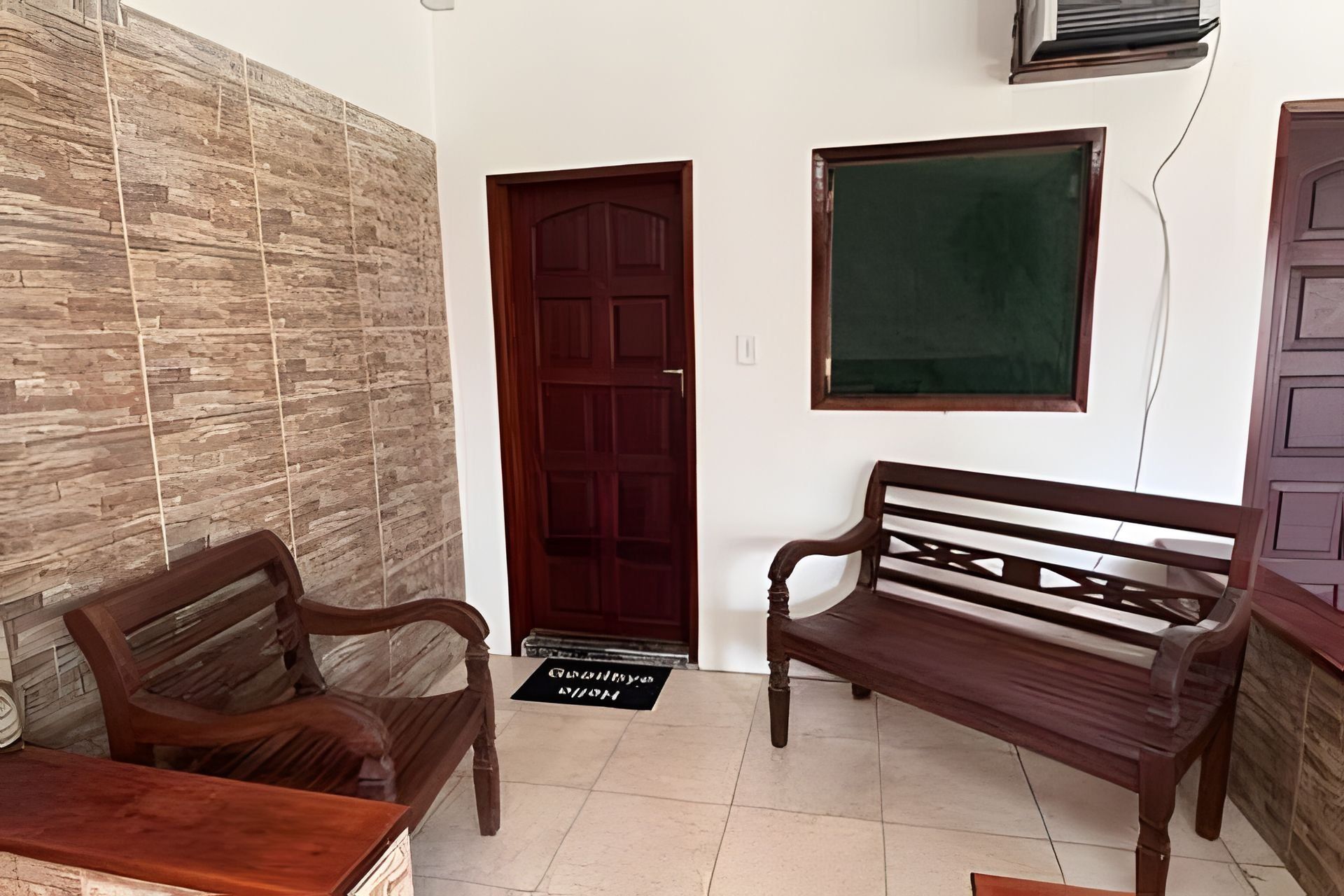 Une pièce avec un banc en bois, une porte et un climatiseur fixé au mur.