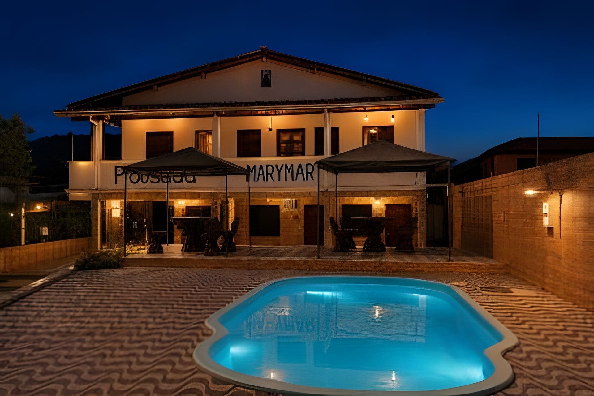 A two-story building with a swimming pool in front.
