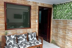 A room with a bench, a large window, and a door leading to another space.