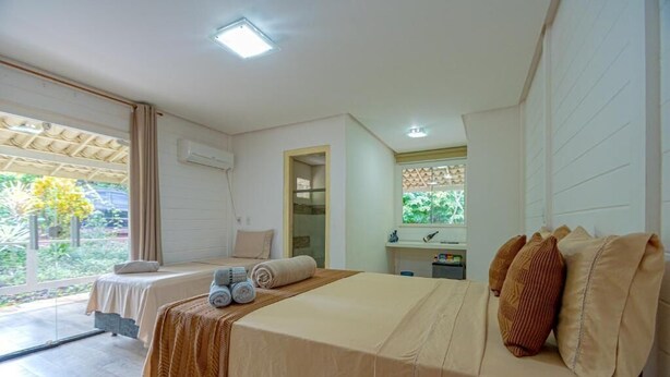 Habitación de hotel con dos camas, un baño y vistas a zonas verdes.
