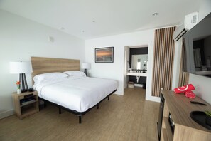 Ein modernes Hotelzimmer mit einem großen Bett, Nachttischen, einem Schreibtisch und einem Spiegel.