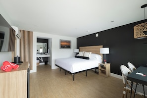 Ein modernes Hotelzimmer mit einem großen Bett, einem Schreibtisch und einem Essbereich.