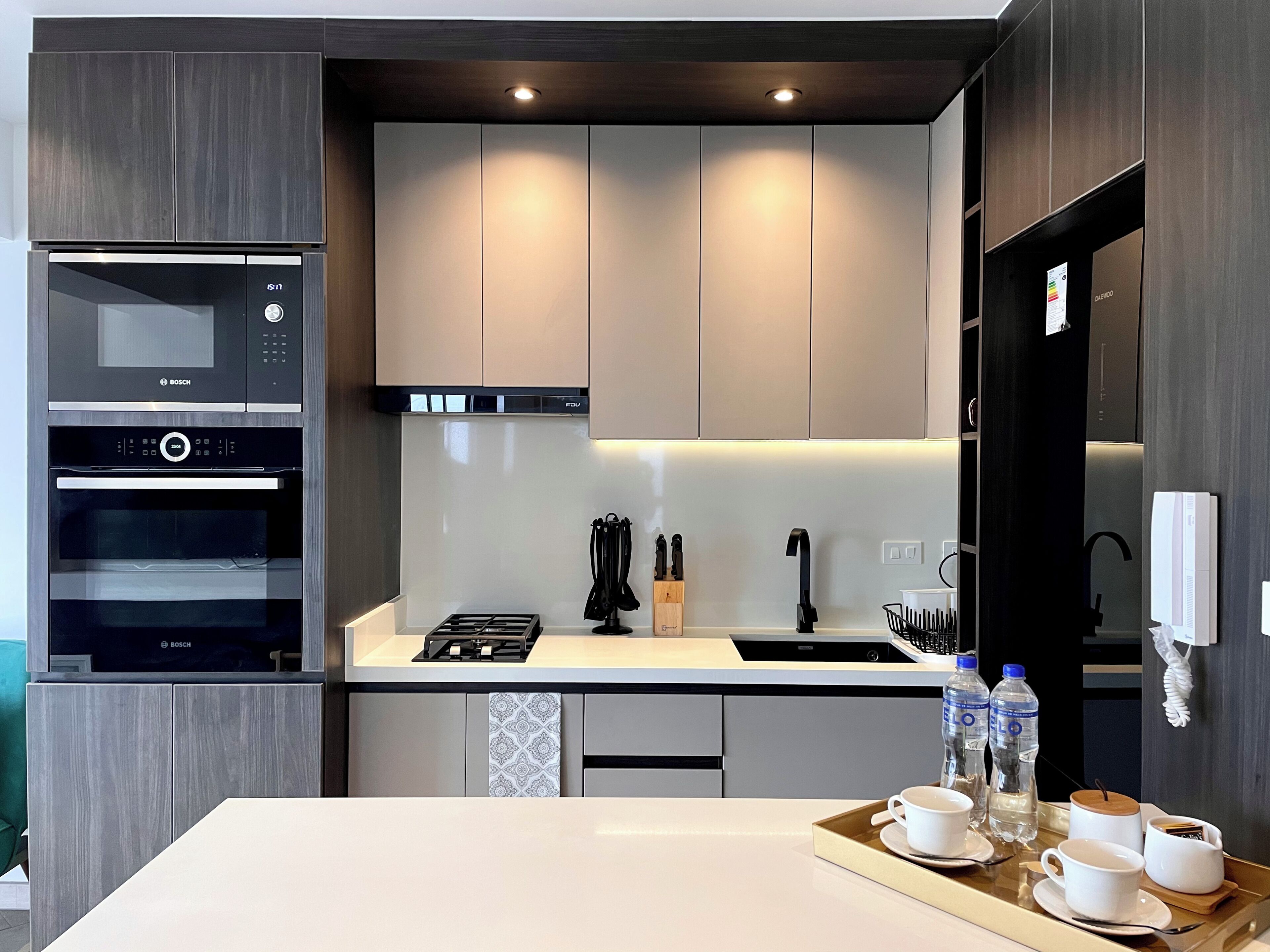 Une cuisine moderne équipée d’appareils électroménagers Bosch, d’une cuisinière à gaz et d’un évier.