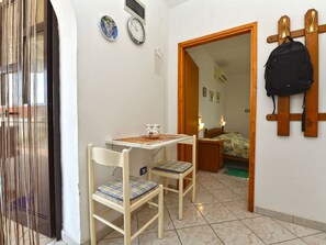 A small room with a table, two chairs, a bed, and a coat rack. - Apartment 372 by Interhome (Medulin)