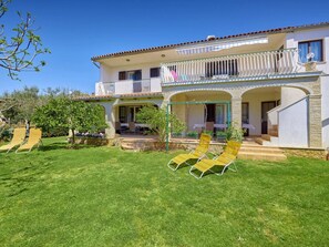 A two-story house with a balcony, a covered porch, and a well-maintained lawn with two lounge chairs. - Apartment 372 by Interhome (Medulin)