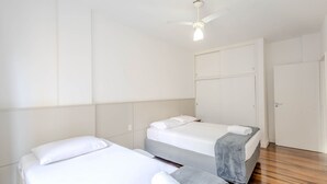 Ein Hotelzimmer mit zwei Betten, einem Deckenventilator und einem Kleiderschrank.