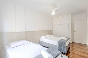 A hotel room with two beds, a ceiling fan, and a wardrobe. - 3BR Apt Sea View Balcony in BC Mrd0051 (Balneário Camboriú)