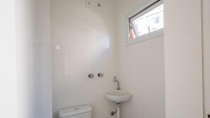 Ein Badezimmer mit Toilette, Waschbecken und Fenster.