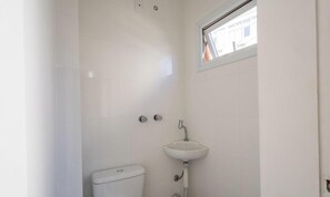 A bathroom with a toilet, a sink, and a window. - 3BR Apt Sea View Balcony in BC Mrd0051 (Balneário Camboriú)