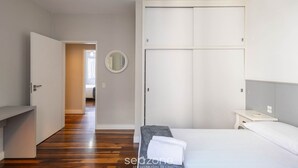 Ein Schlafzimmer mit Bett, Nachttisch, Kleiderschrank und Spiegel.
