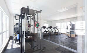 A gym with exercise equipment, treadmills, and a weightlifting station. - Full Studio in Jardim Goias Msst1001 (Goiânia)