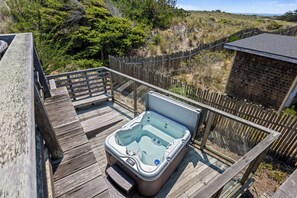 Ein Whirlpool auf einer Holzterrasse mit Blick auf die umliegende Landschaft.