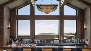 A bar area with a view of a coastal landscape through large windows. - Miwok Escape, by Vinifera Homes (Bodega Bay)