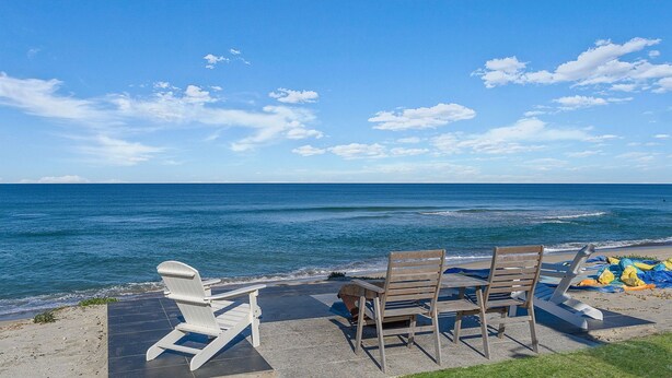 A beachside seating area with a view of the ocean.