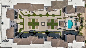 An aerial view of a hotel with a central courtyard, multiple buildings, and a swimming pool. - Downtown Naples Escape | Resort Pool | Luxury Condo (Naples)