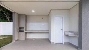 Un área de cocina exterior moderna con horno empotrado, lavamanos y encimera.