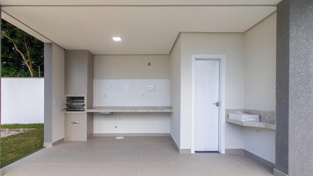 Un'area cucina esterna moderna con forno integrato, lavello e piano di lavoro.
