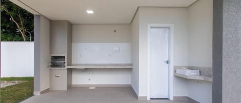 A modern outdoor kitchen area with a built-in oven, a sink, and a countertop.