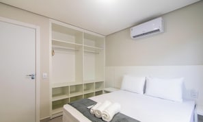 Een hotelkamer met een bed, een inloopkast en een airconditioningsysteem.