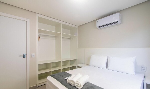 Een hotelkamer met een bed, een kledingkast en een airconditioning.