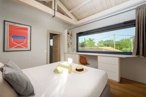 A bedroom with a bed, a desk, a window with a view, and a framed picture on the wall. - Villa Casa LaBobina (Istria - Kurili) (Kurili)