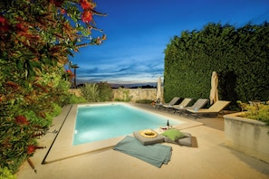 A rectangular swimming pool with lounge chairs and a stone wall in the background. - Villa Casa LaBobina (Istria - Kurili) (Kurili)