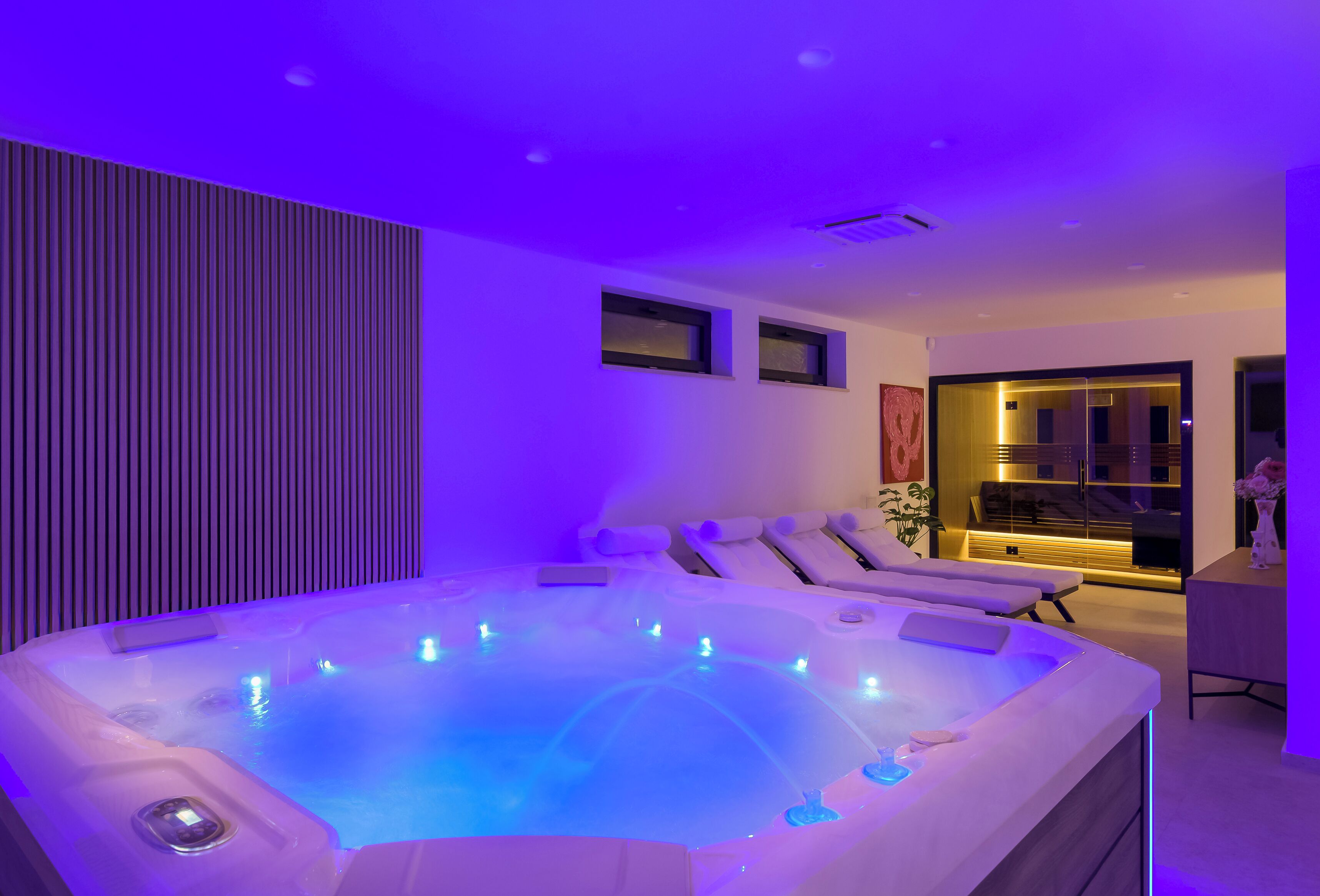Ein moderner Wellnessbereich mit Whirlpool, Massagesesseln und einer Rezeption.