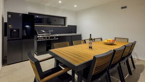 Una cocina moderna con horno y microondas integrados, una mesa de comedor con sillas y un ventilador de techo.